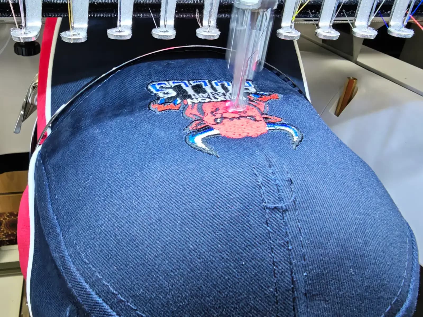 Buxton Bulls cap logo being embroidered on the OK T-Shirt embroidery machine