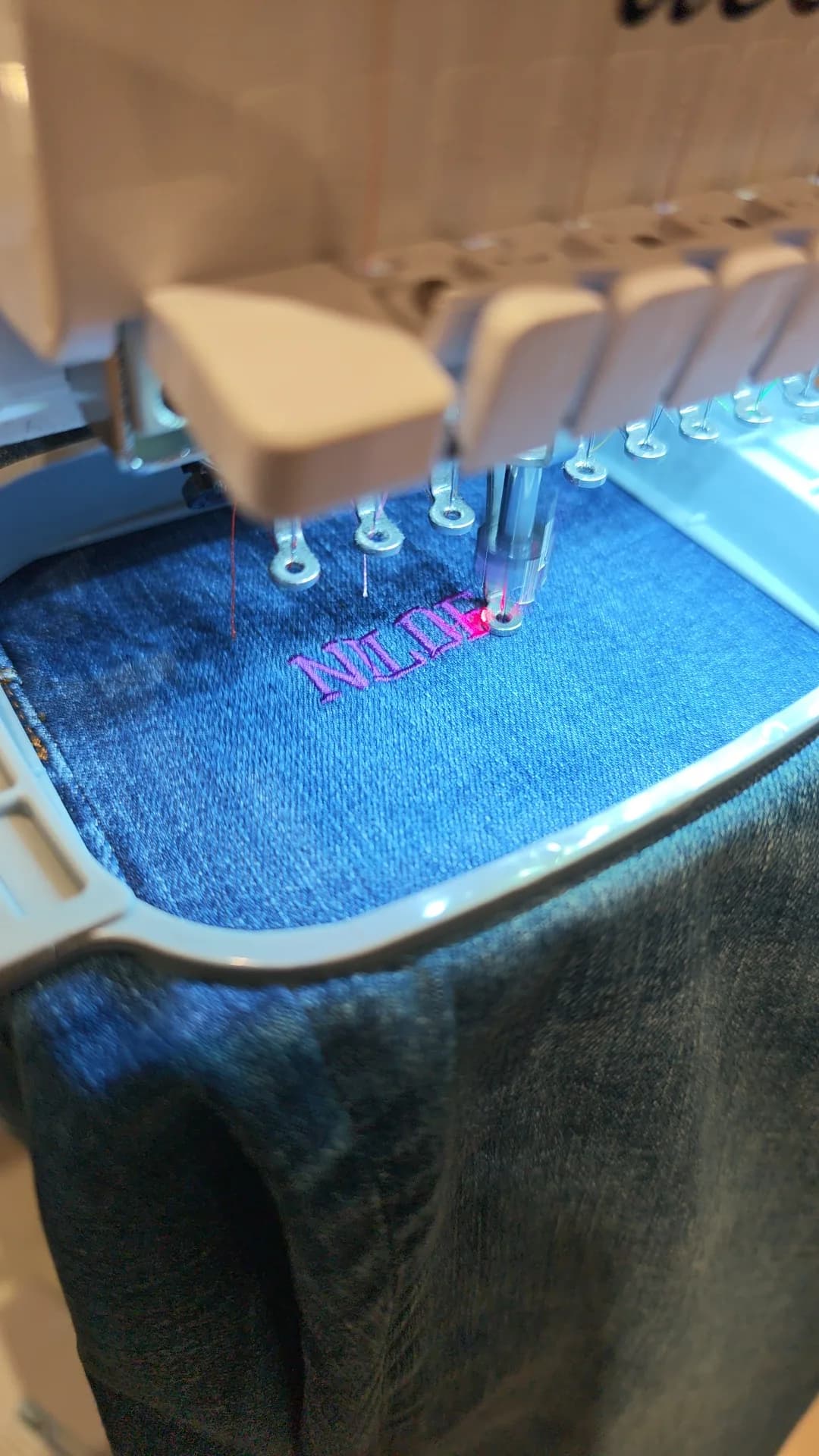 A customer name being embroidered onto River Island jeans during the activation