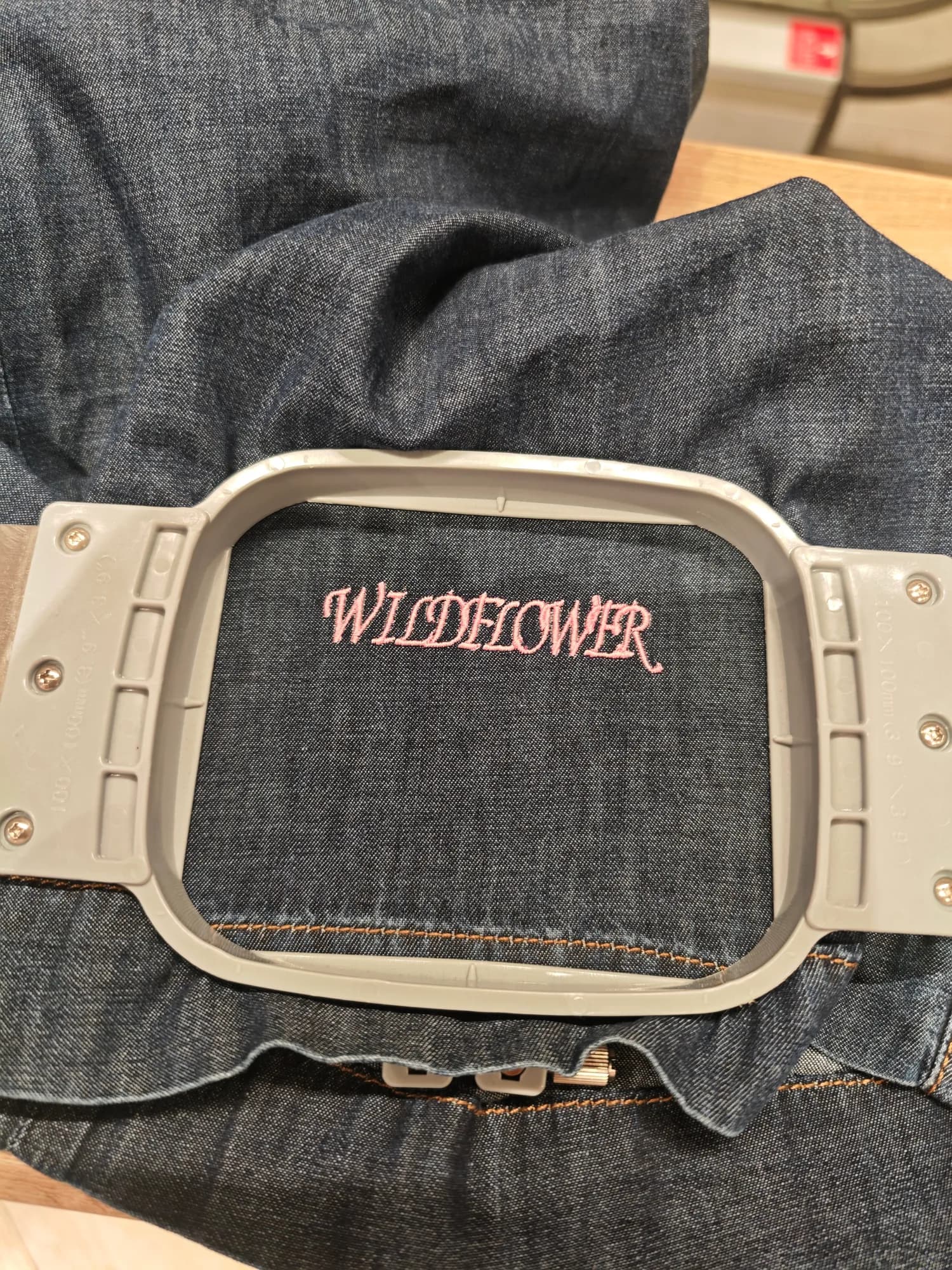 Finished River Island jeans with Wildflower embroidery displayed at the activation