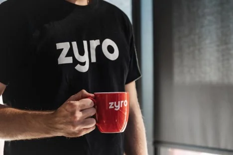 man waring a black t-shirt and keeping a red mug in his right hand